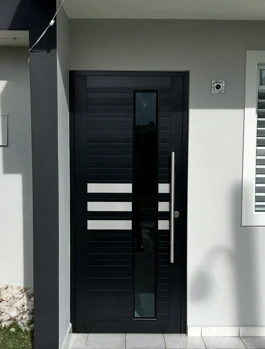 Puerta de entrada negra moderna con franjas de cristal y tirador de acero