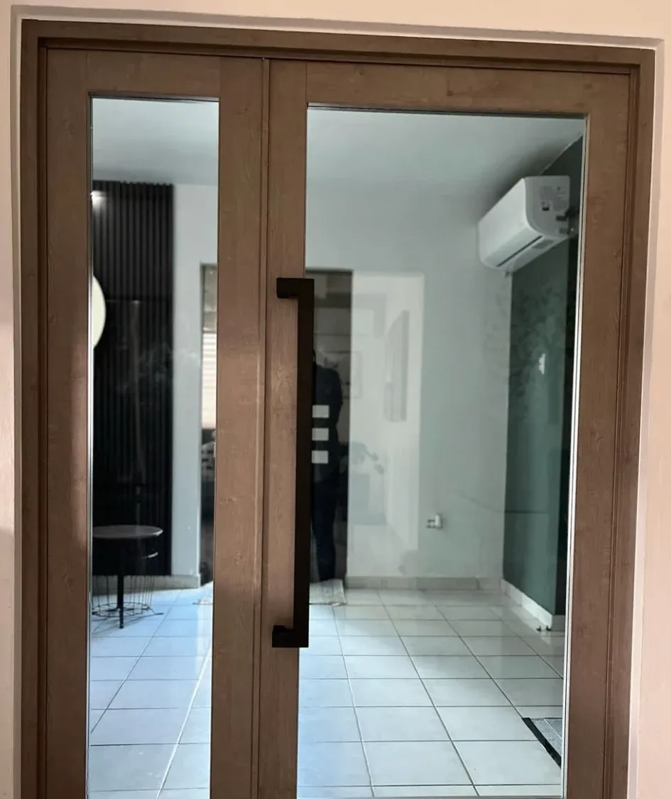 Puerta doble en acabado madera con cristal y tirador negro