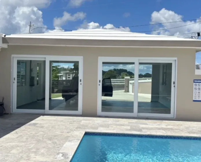 Dos puertas corredizas de cristal frente a una piscina